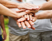 A group of people putting their hands on top of each other.