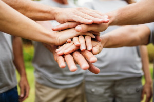 A group of people putting their hands on top of each other.